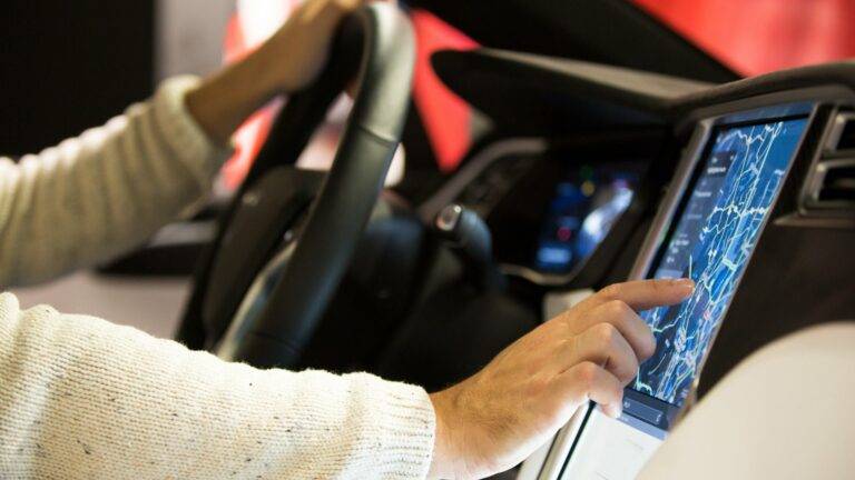 Driver using a car's touchscreen navigation system.